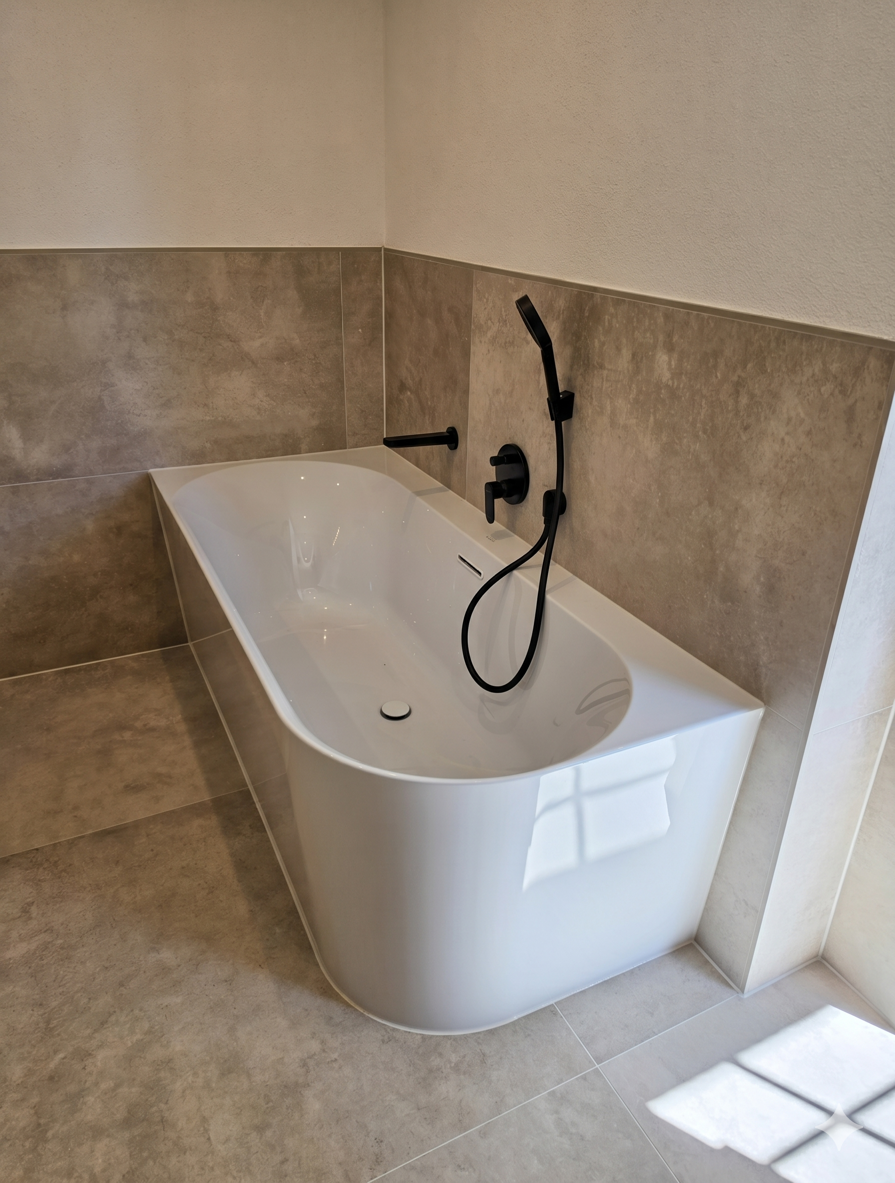 Badewanne mit schwarzem Duschset und Fliesen